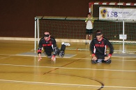 Bild: Jürgen und Harald hocken nebeneinander am Spielfeld und positionieren sich soeben